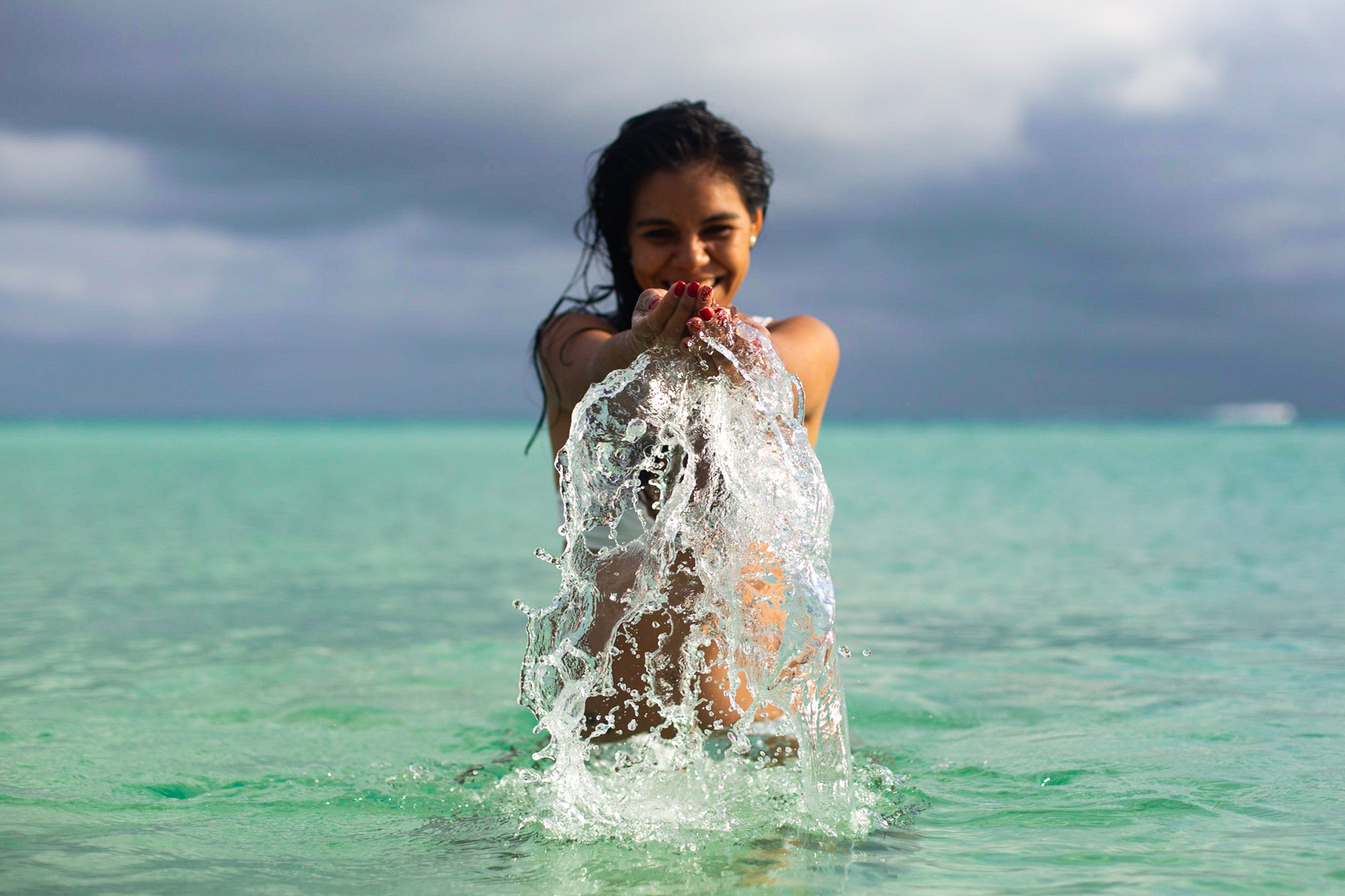 Foto de mujer en Bikini en el mar de Playa del Carmen, la Riviera Maya. Congelando el agua en sus manos.